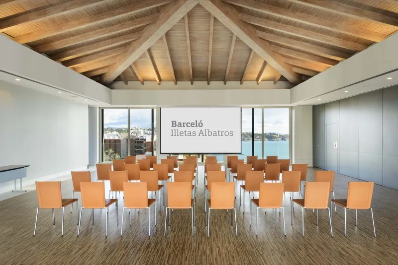 Konferenzraum mit offener Holzbalkendecke und Fensterfront zum Meer